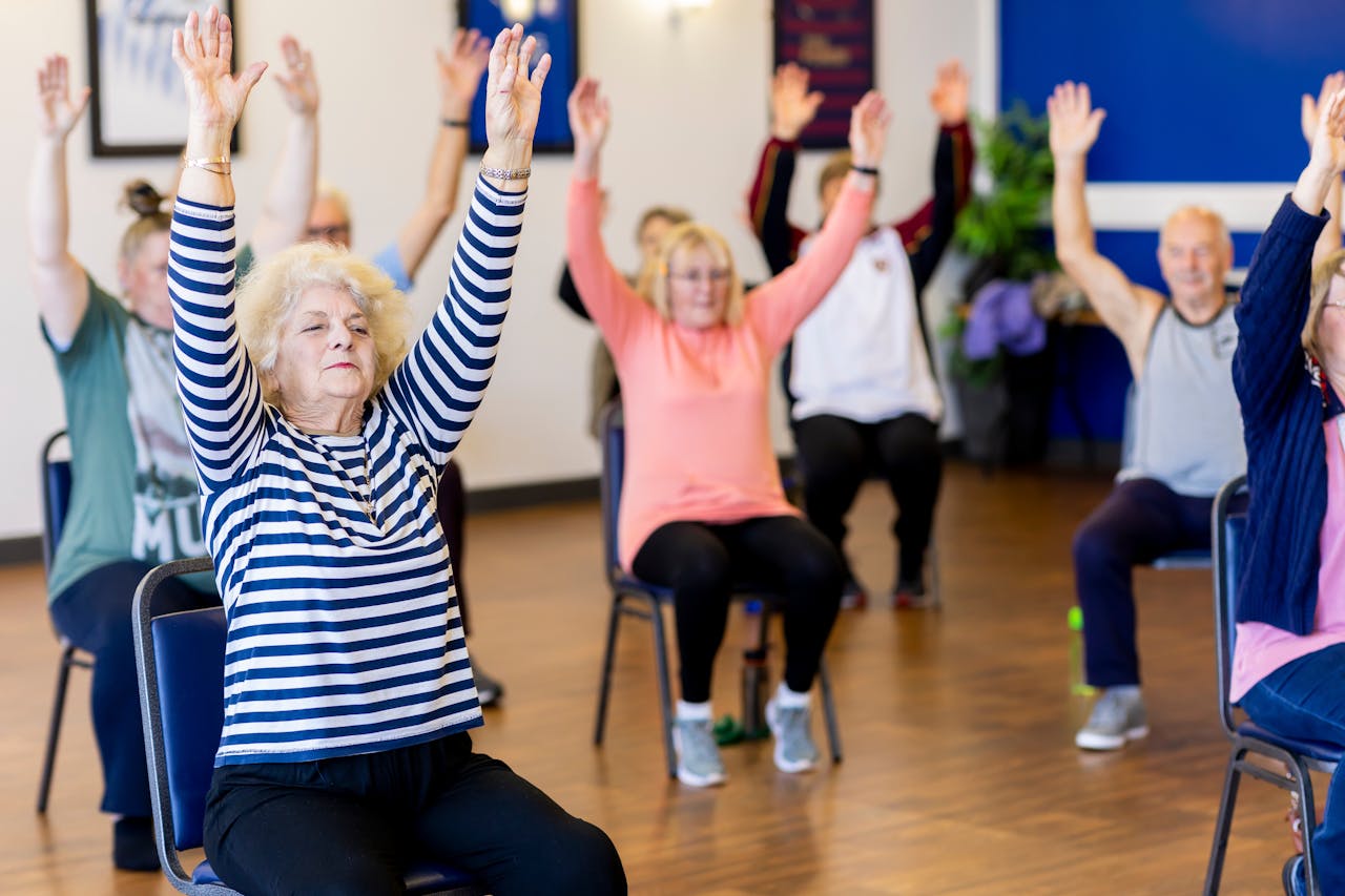 why-choose-us Group of senior adults participating in a chair exercise class, promoting fitness and healthy lifestyle.